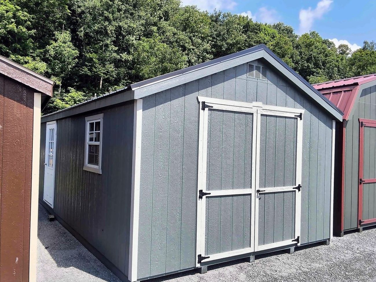 Gray LP SmartSide shed with white trim